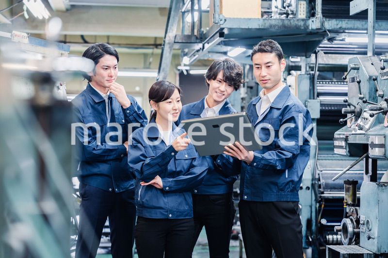 タブレット端末を見ながら会議をする工場スタッフ
