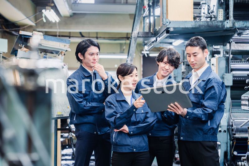 タブレット端末を見ながら会議をする工場スタッフ
