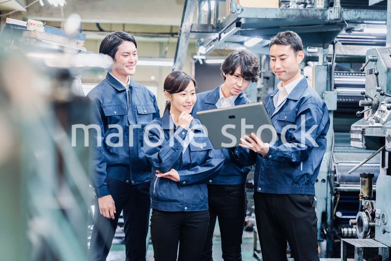 タブレット端末を見ながら会議をする工場スタッフ