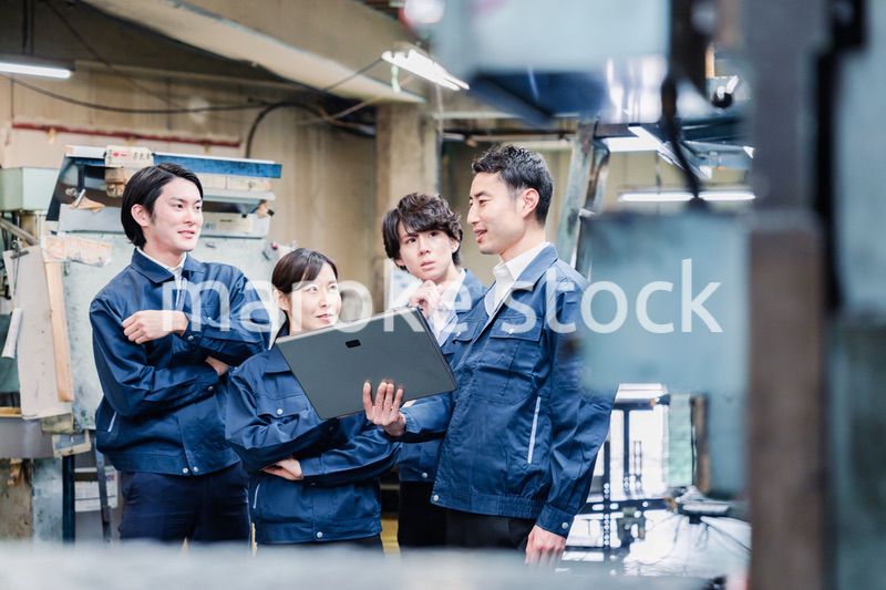タブレット端末を見ながら会議をする工場スタッフ