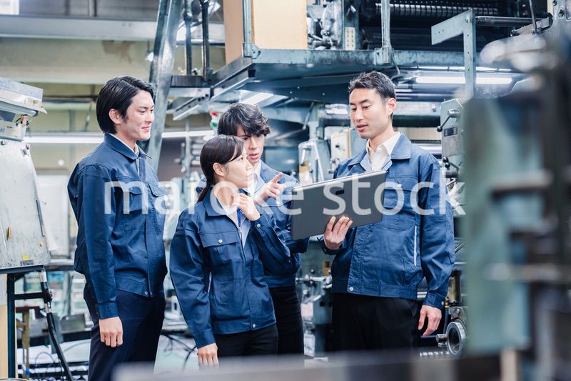 タブレット端末を見ながら会議をする工場スタッフ