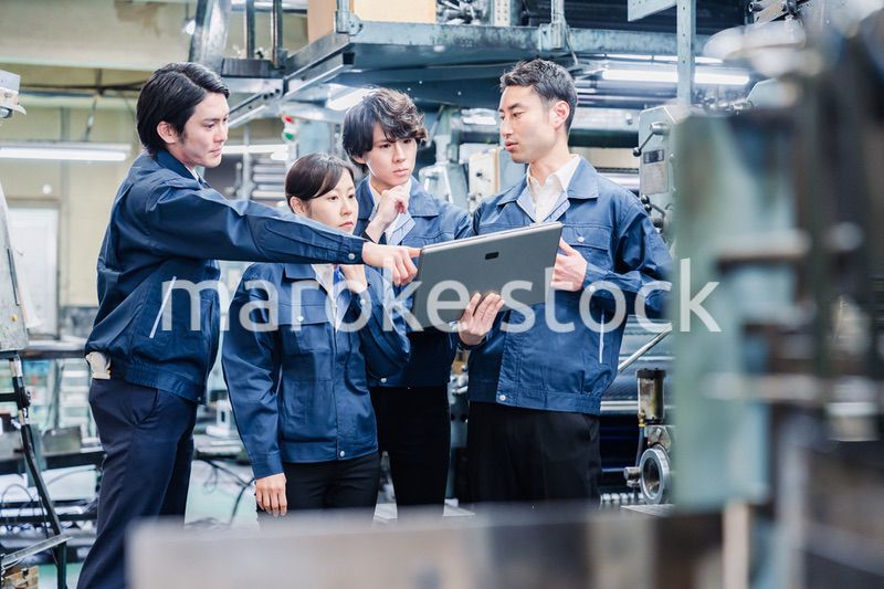 タブレット端末を見ながら会議をする工場スタッフ