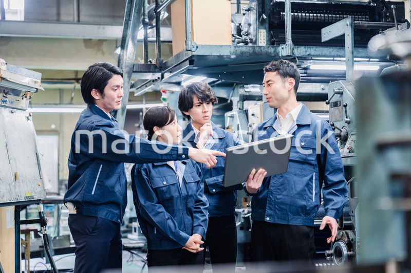 タブレット端末を見ながら会議をする工場スタッフ