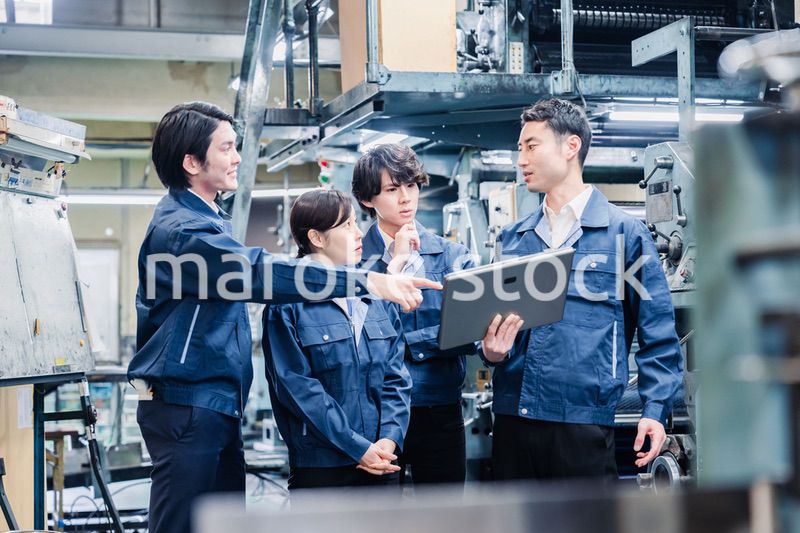 タブレット端末を見ながら会議をする工場スタッフ