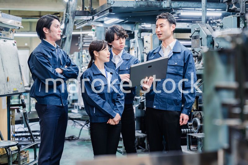 タブレット端末を見ながら会議をする工場スタッフ