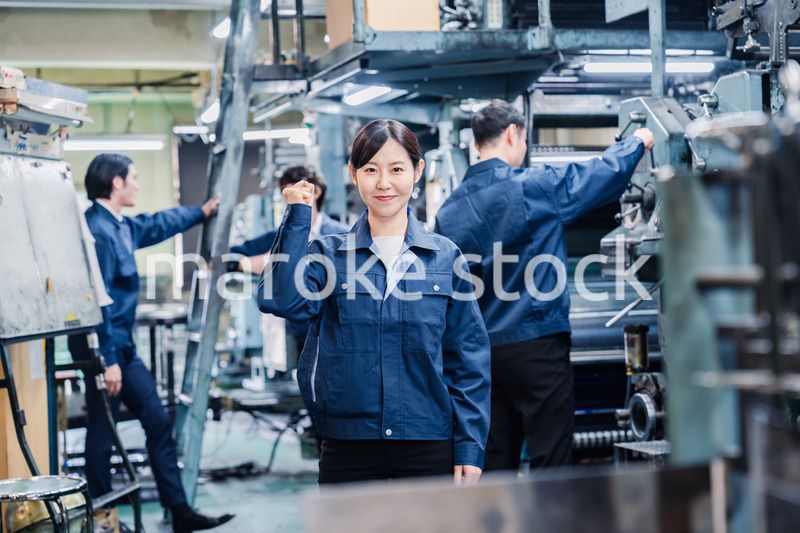 ガッツポーズをする工場労働者
