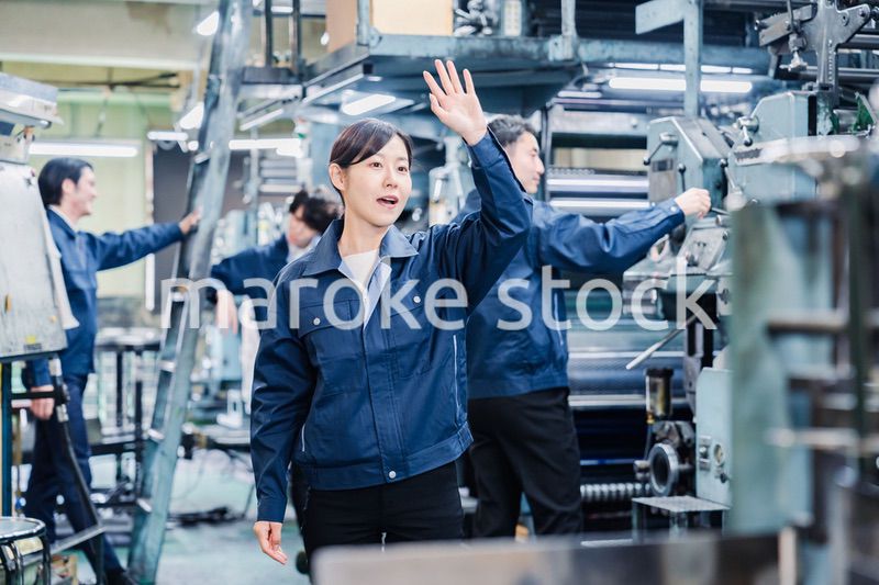 工場で手をふる女性の労働者