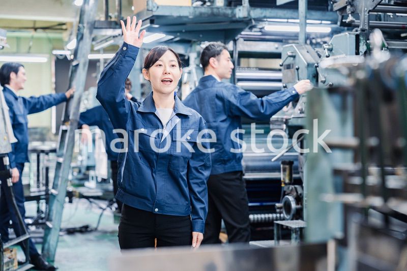 工場で手をふる女性の労働者