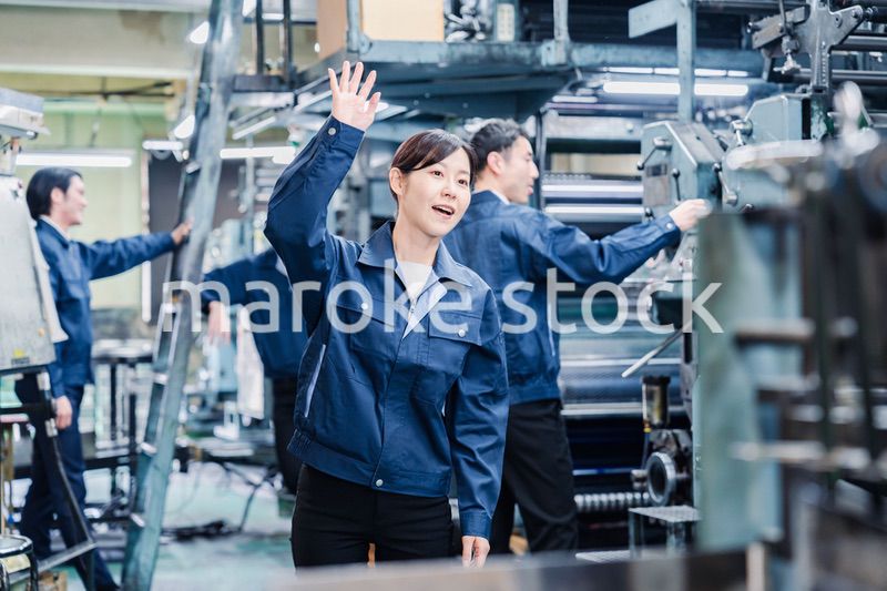工場で手をふる女性の労働者