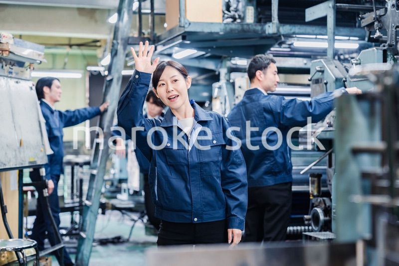 工場で手をふる女性の労働者