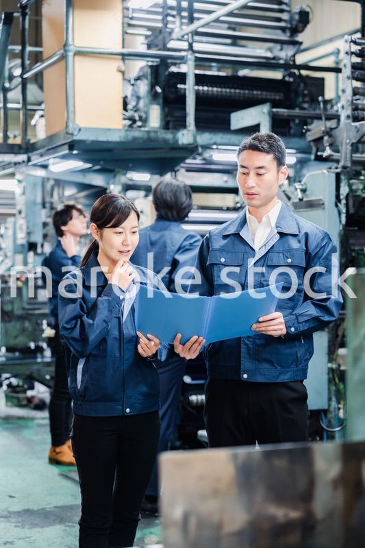 工場で生産計画を確認する労働者