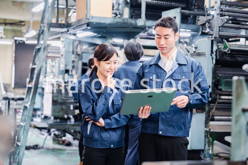 タブレットを見ながら工場で議論をするスタッフ