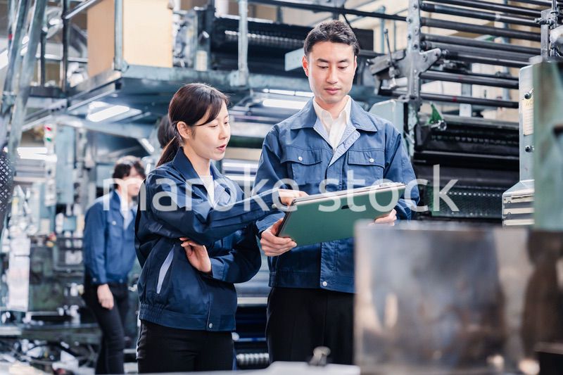 タブレットを見ながら工場で議論をするスタッフ