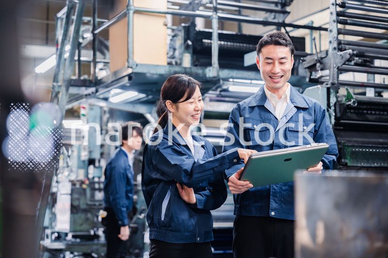 タブレットを見ながら工場で議論をするスタッフ