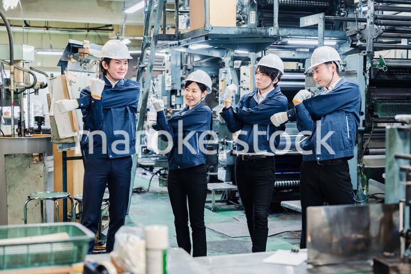 始業前の体操をする工場労働者