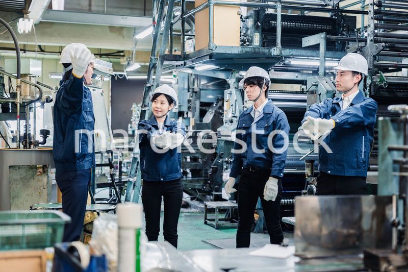 始業前の体操をする工場労働者