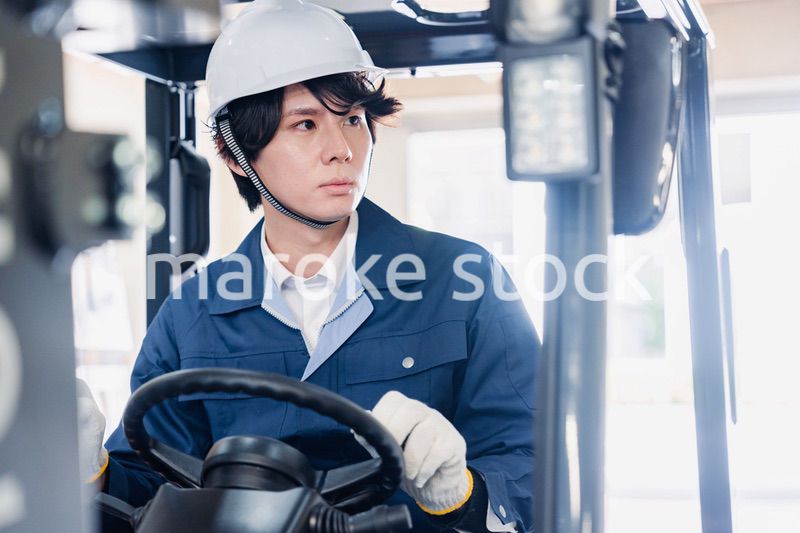 建設現場で重機に乗る作業員