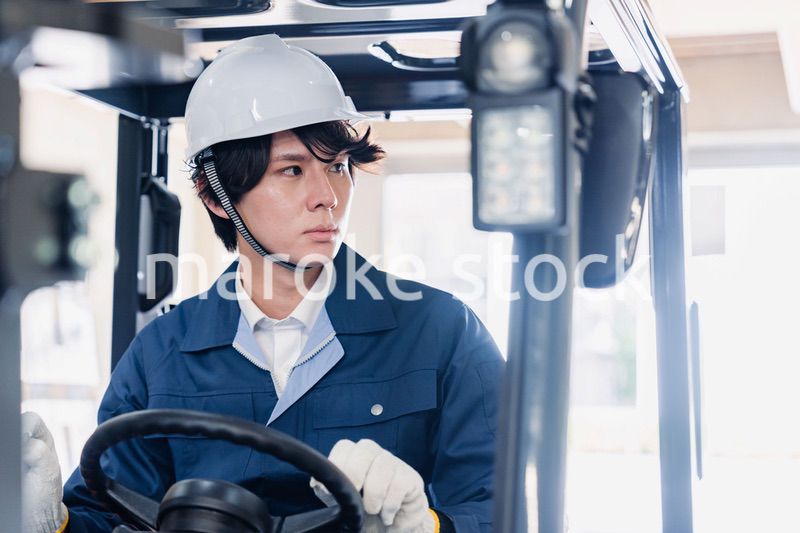 建設現場で重機に乗る作業員