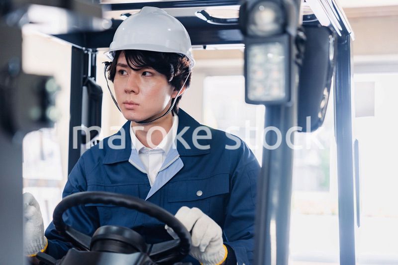 建設現場で重機に乗る作業員