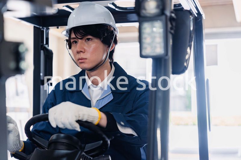 建設現場で重機に乗る作業員