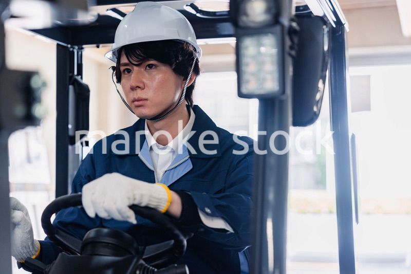 建設現場で重機に乗る作業員