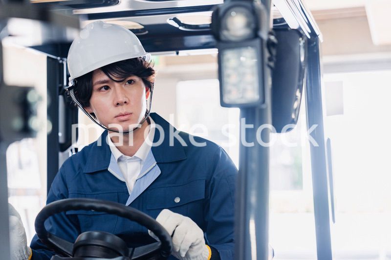 建設現場で重機に乗る作業員