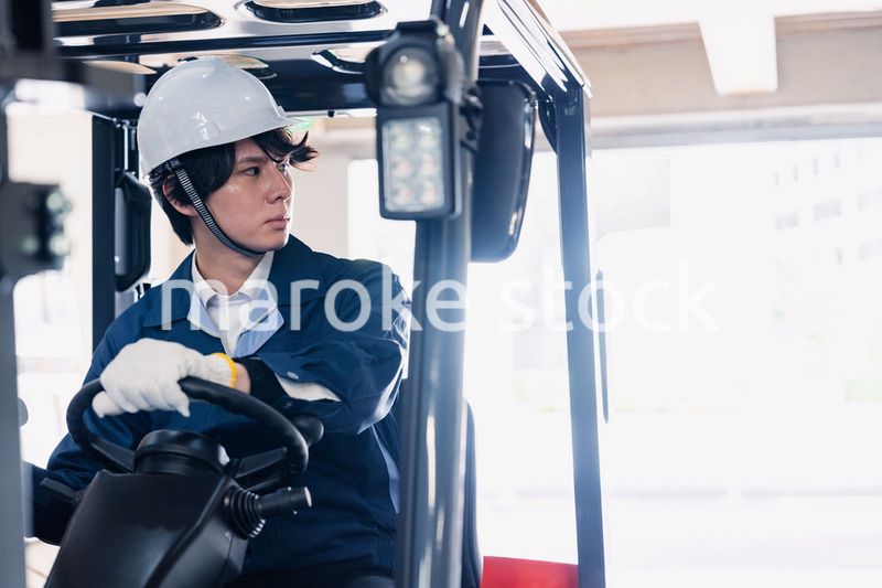 建設現場で重機に乗る作業員