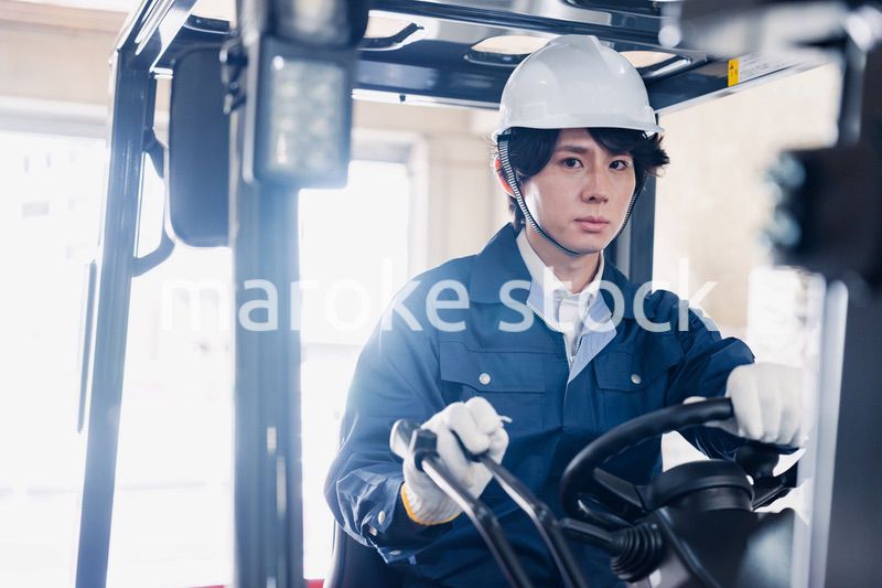 建設現場で重機に乗る作業員