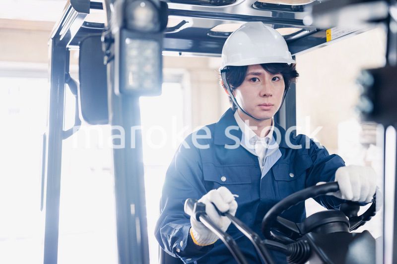 建設現場で重機に乗る作業員