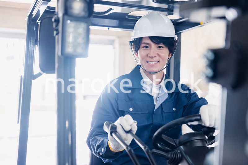 建設現場で重機に乗る作業員