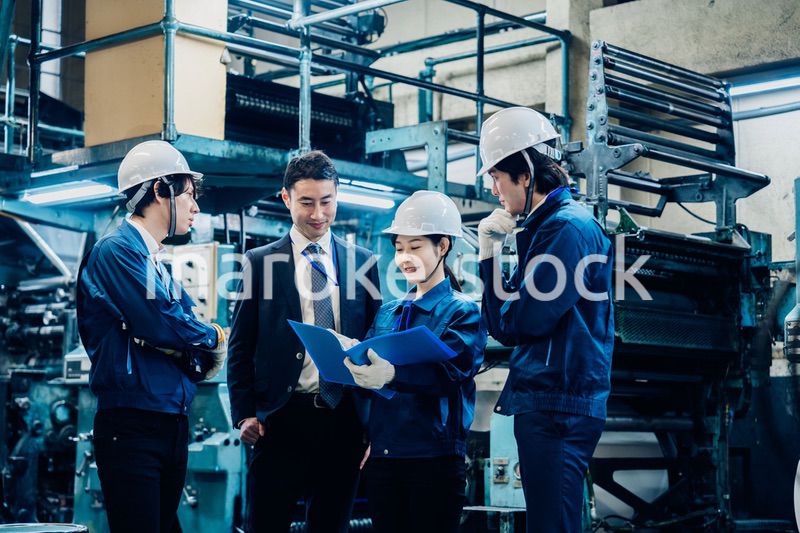 工場で資料を確認する労働者