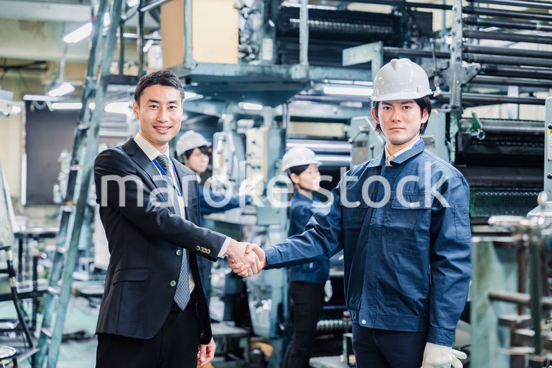 取引先と握手をする工場のスタッフ
