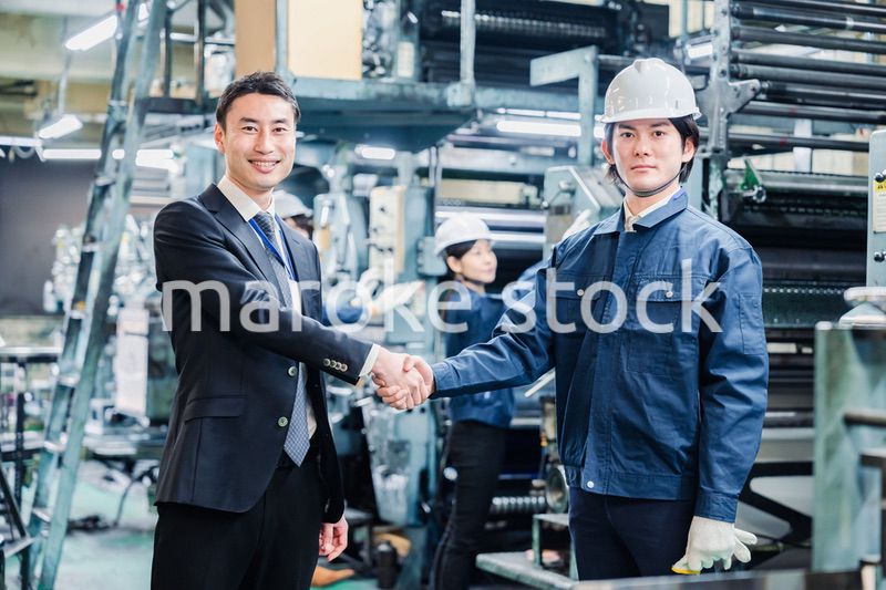 取引先と握手をする工場のスタッフ