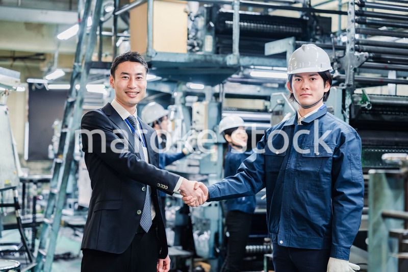取引先と握手をする工場のスタッフ