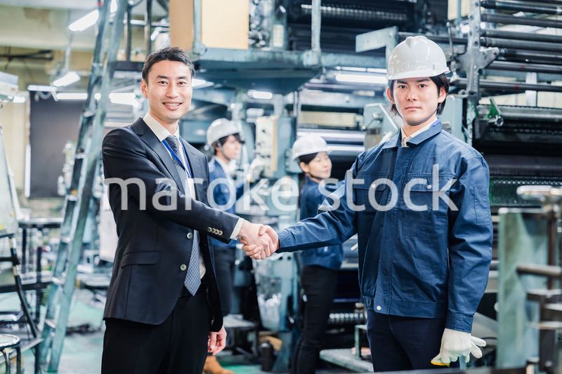 取引先と握手をする工場のスタッフ