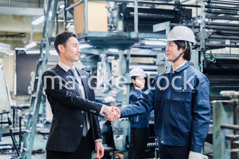 取引先と握手をする工場のスタッフ
