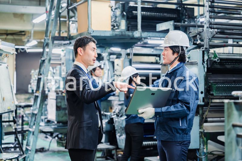 工場を視察するビジネスマン