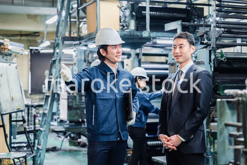工場を視察するビジネスマン