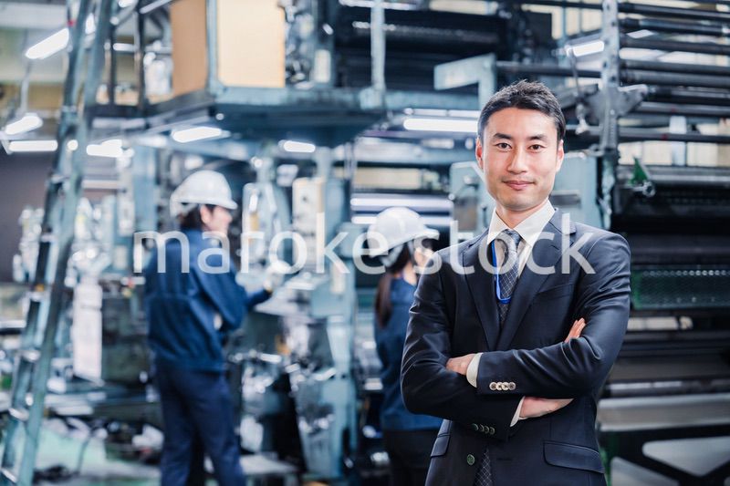 工場で腕を組むホワイトカラーの男性