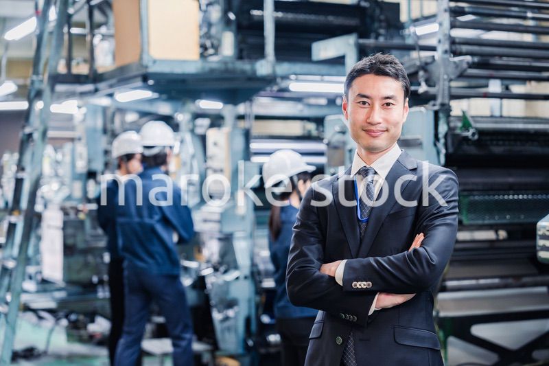 工場で腕を組むホワイトカラーの男性