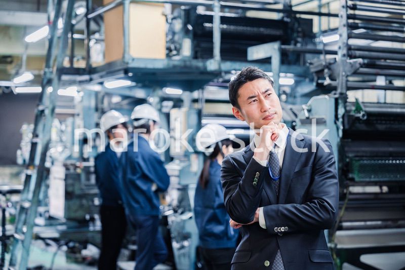 工場で悩むビジネスマン