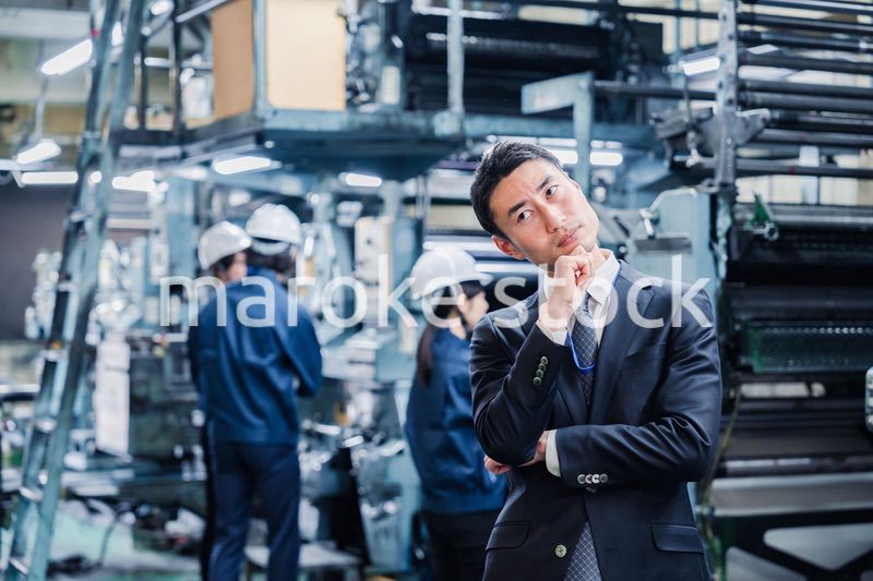 工場で悩むビジネスマン