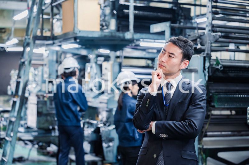 工場で悩むビジネスマン