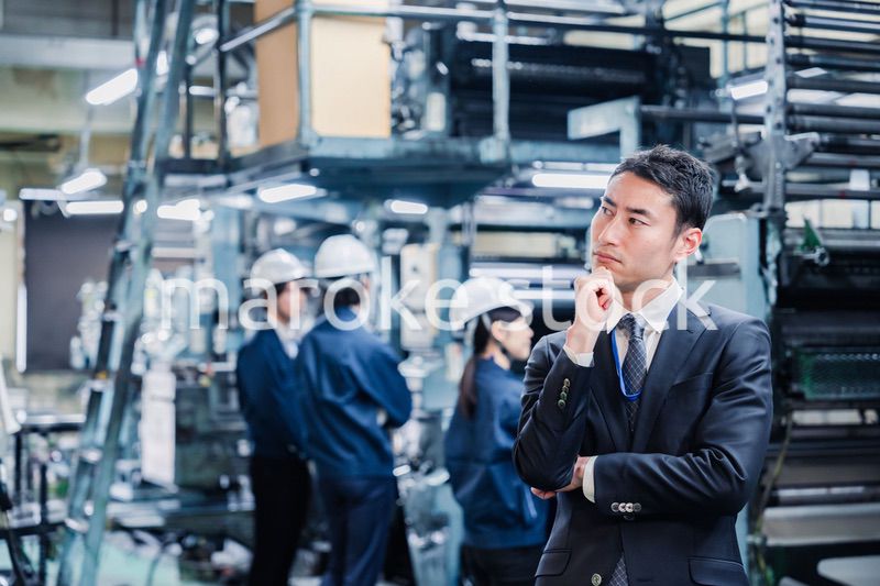 工場で悩むビジネスマン