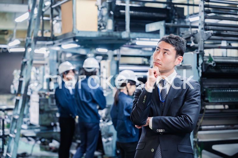 工場で悩むビジネスマン