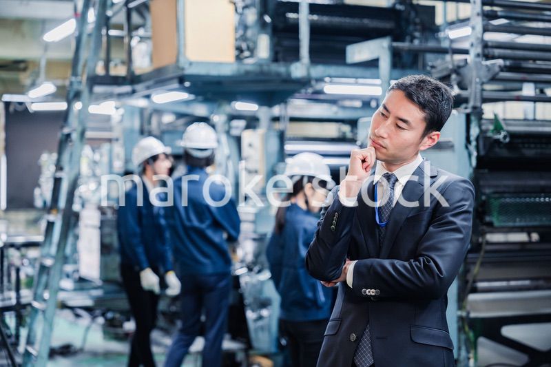 工場で悩むビジネスマン