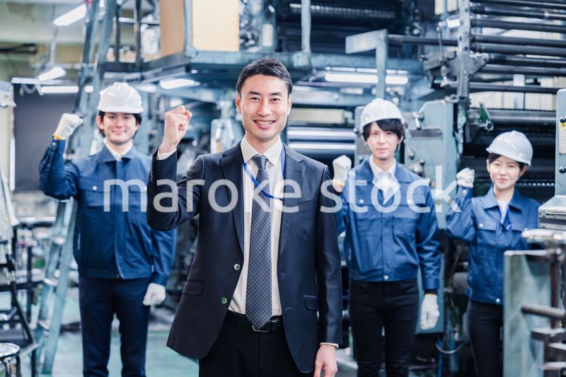 工場でガッツポーズをするスタッフたち