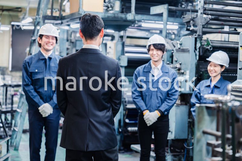 管理職の訓示を聴く工場スタッフ