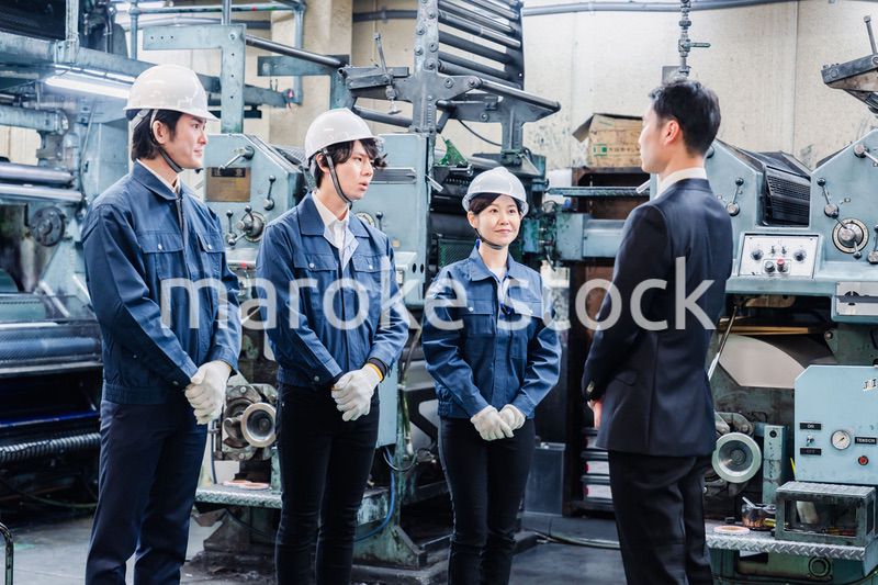 管理職の訓示を聴く工場スタッフ