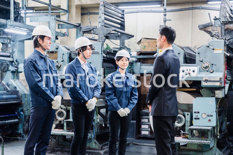 管理職の訓示を聴く工場スタッフ